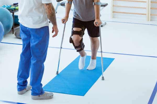 A picture of a man with a leg injury undergoing physical therapy