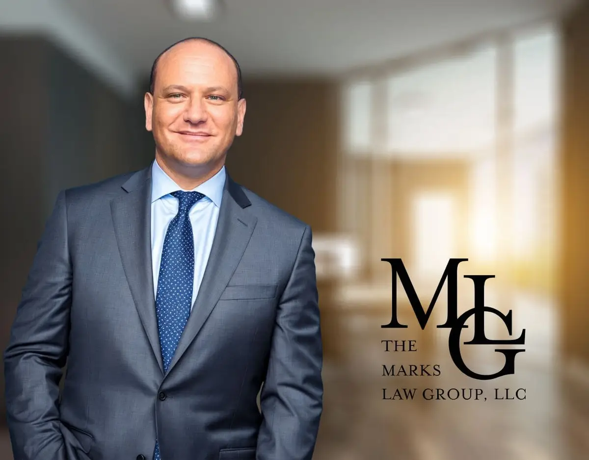 Man in a grey suit and blue tie standing in an office hallway