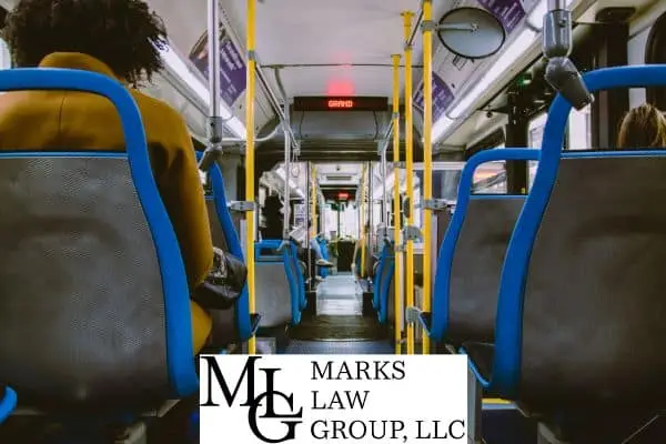 Interior of a city transit bus with passengers seated along the aisle