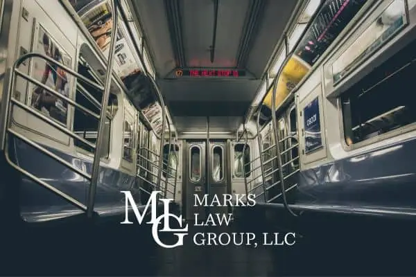 The empty interior of a subway train car with poles and seats