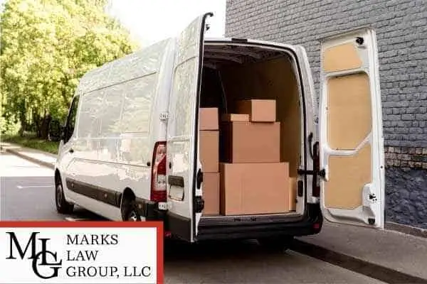 White delivery van with its rear doors open and cardboard parcels stacked inside