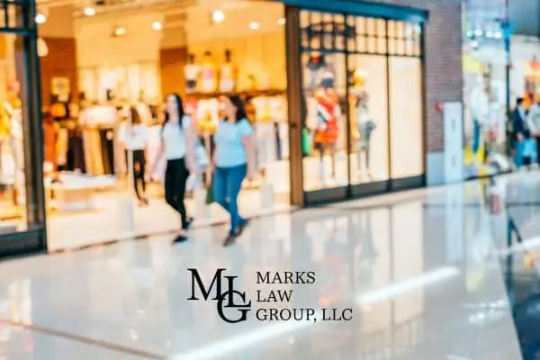 Two women walking past shop windows in a bright shopping mall