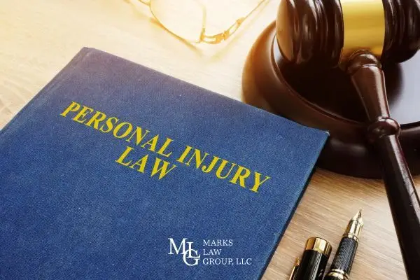 Personal injury book on desk with gavel and pen next to it