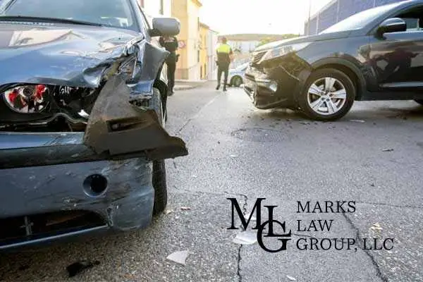 Two cars with crumpled front ends after a collision on a narrow street
