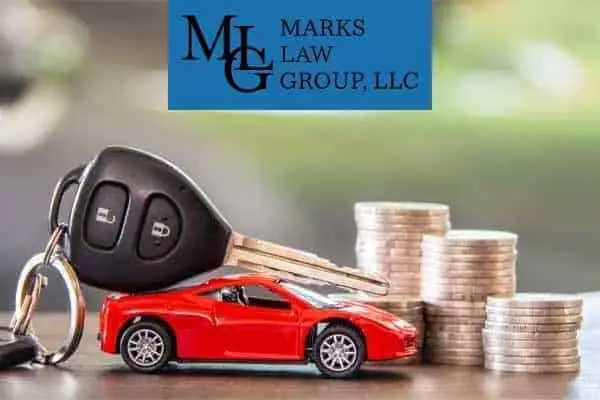 Car key fob and a red toy car beside stacks of coins