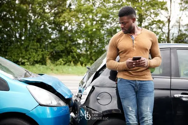 a man looking at his car after being rear-ended