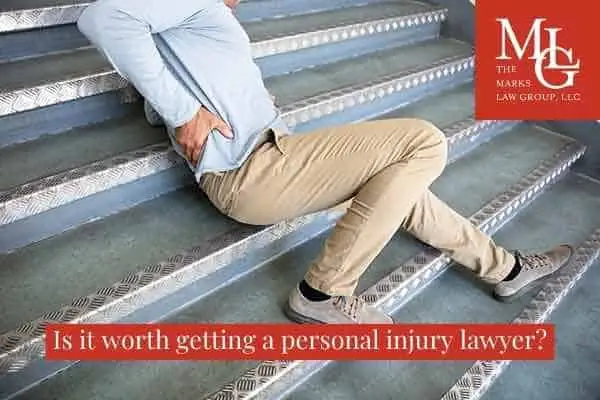man clutching his back on stairs, captioned "Is it worth getting a personal injury lawyer?"