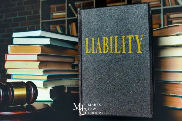 a stack of books covering injury law and liability and a gavel on a desk