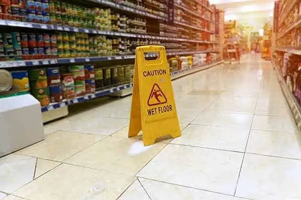 yellow caution wet floor sign standing in a grocery store aisle