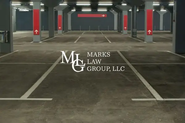 An empty underground parking garage with red arrow markings on the pillars