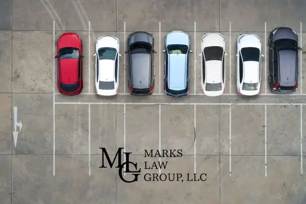 Overhead view of seven cars parked in a row in a marked lot