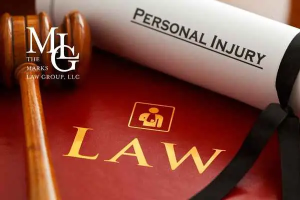 A rolled document marked Personal Injury resting on a red book titled Law