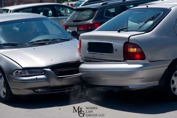 A car with a crushed front end pressed into the rear bumper of another car