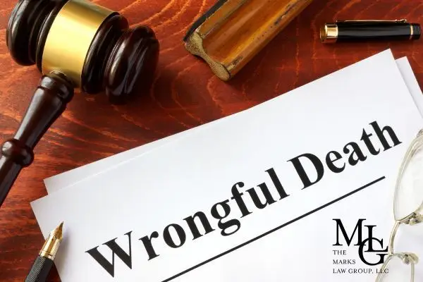 Papers headed Wrongful Death on a desk with a gavel and glasses