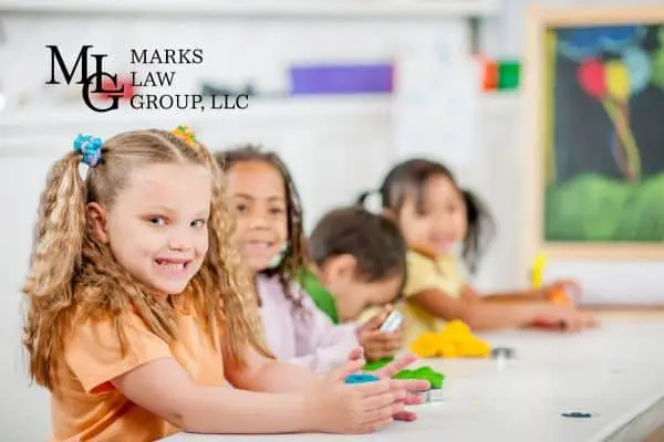Young children playing with modelling clay at a day care table