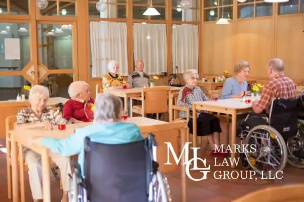 Elderly residents seated at tables in a nursing home dining room