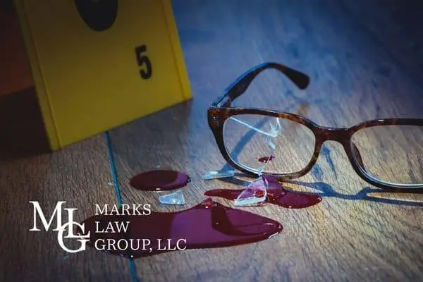 Broken eyeglasses in a pool of blood beside a yellow evidence marker numbered 5