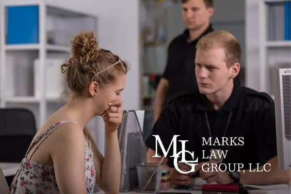 Distressed young woman being interviewed by an officer at a desk