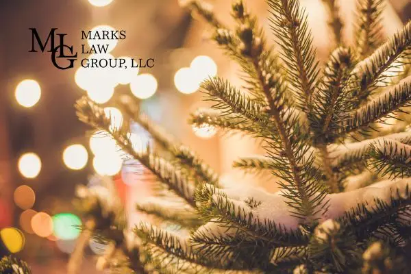 Close-up of a pine branch against warm blurred holiday lights