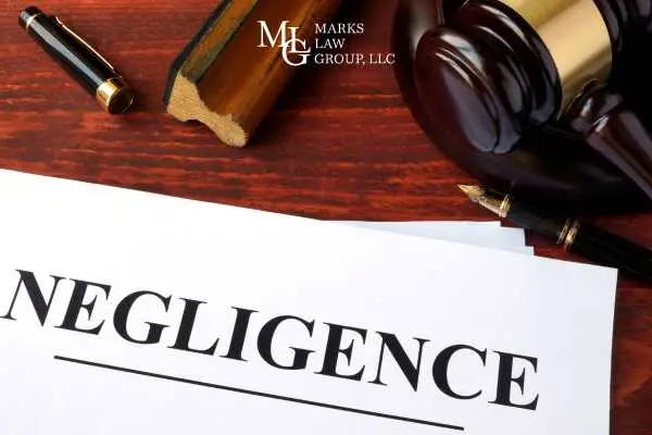 Papers headed Negligence on a desk with a gavel and fountain pen
