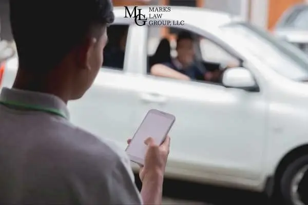 A man holding a phone as a white car with a driver pulls up beside him