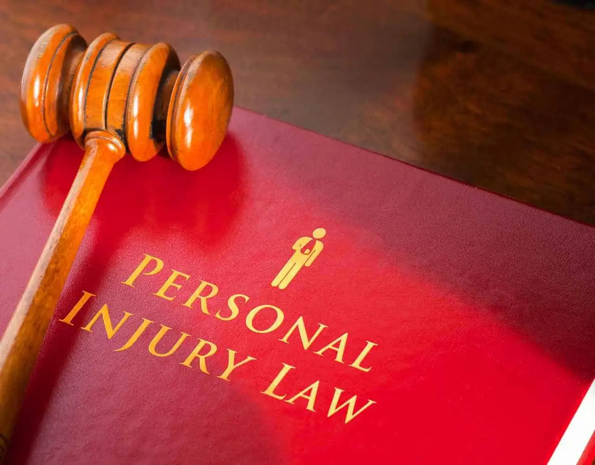 a gavel and a red injury law book on a desk
