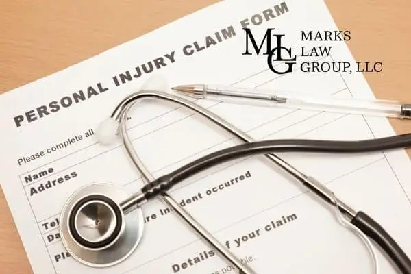 A personal injury claim form on a desk with a stethoscope and pen