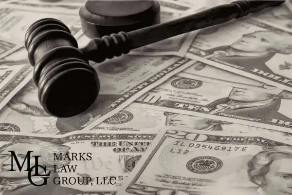 A judge's gavel resting on a spread of scattered dollar bills