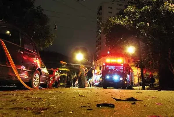 Fire engine and wrecked car on a city street at night