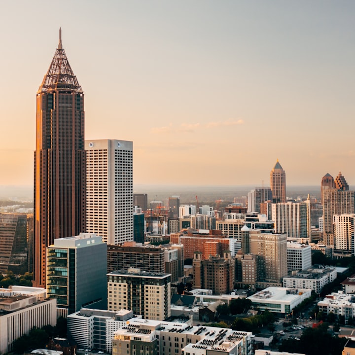 Atlanta skyline at sunset with a tall spired tower above the downtown blocks
