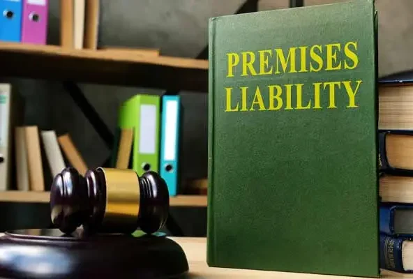 Green book titled Premises Liability beside a gavel on a desk