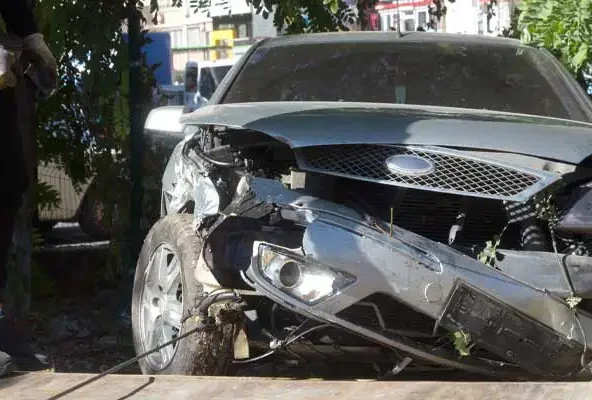 Car with a torn-off front bumper and shattered headlight after a crash