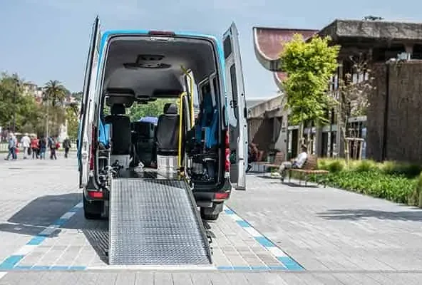 Wheelchair van parked with its rear ramp lowered onto a pavement