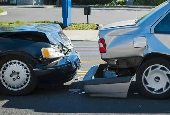 Black car with a crumpled bonnet pushed into the rear of a silver car