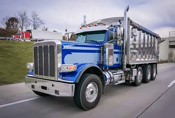 Blue dump truck driving along a highway