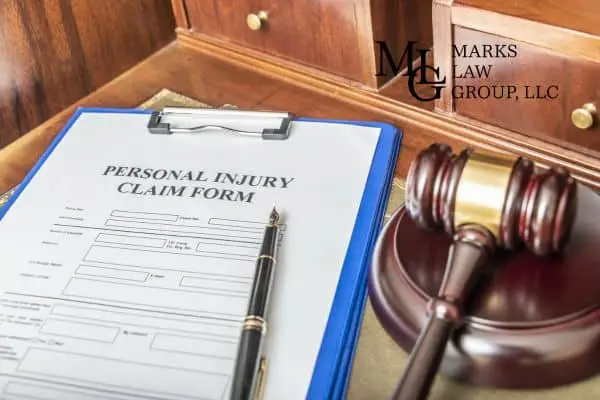 A blank Personal Injury Claim Form on a clipboard beside a gavel