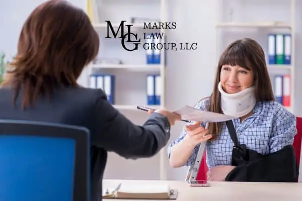 A woman in a neck brace and arm sling handing documents across an office desk
