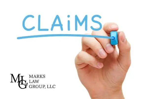A hand underlining the handwritten word Claims with a blue marker