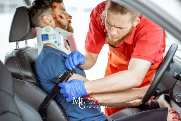 Paramedic in blue gloves attending to a car accident victim with a neck brace, applying a tourniquet.