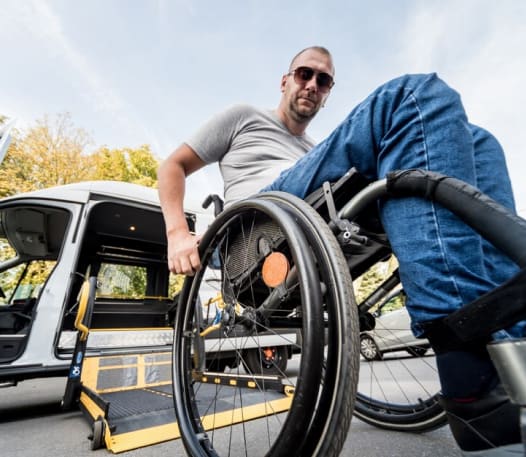 Man in a wheelchair boarding a non-emergency medical transport van