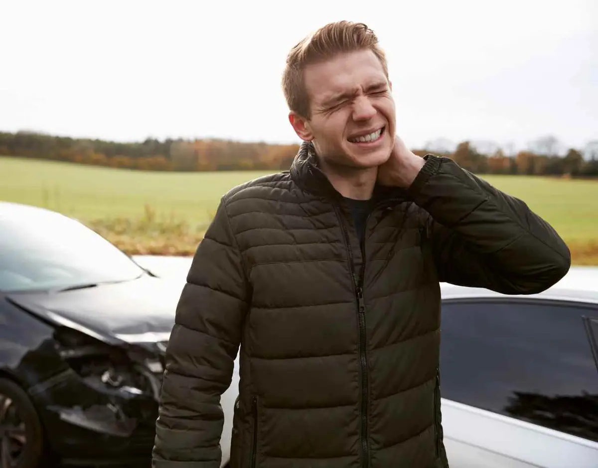a man holding his injured neck after a car accident