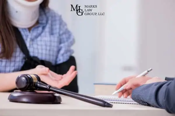 an injured woman meeting with a lawyer to talk about filing a claim