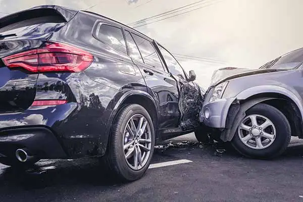 Black SUV crashed into the front of a grey SUV in a parking lot