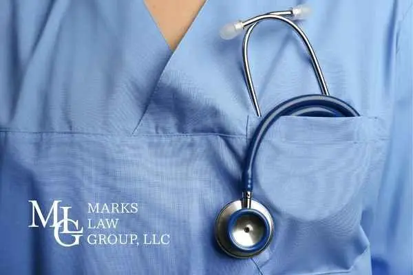 A stethoscope hanging from the pocket of blue medical scrubs
