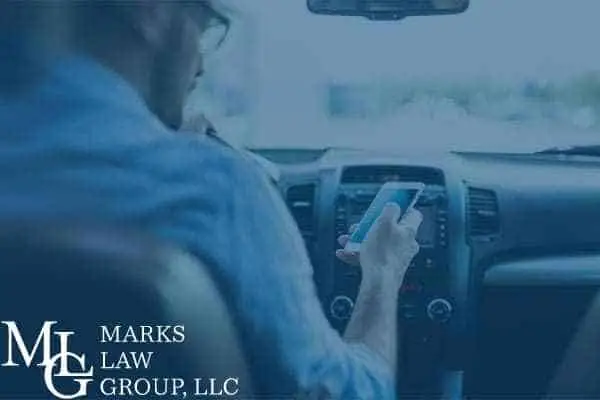 A driver looking down at a smartphone while at the wheel