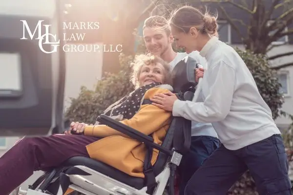 Paramedics wheeling a smiling elderly woman on a stretcher to an ambulance